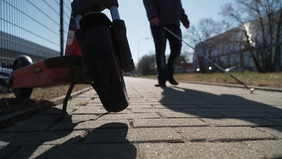 E-Roller und Blindenstock auf dem Gehweg. © NDR Foto: Maximilian Pilz