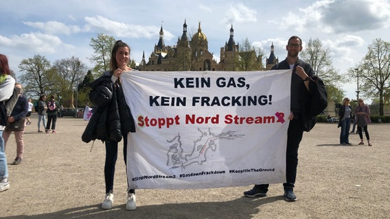 Zwei Demonstranten halten vor dem Schweriner Schloss ein Transparent mit der Aufschrift "Kein Gas, kein Fracking! Stoppt Nord Stream" © NDR Foto: Emma  Schilling