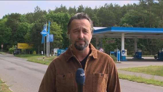 NDR Reporter Stefan Weidig vor einer Tankstelle.  