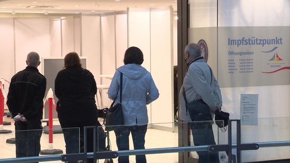 Menschen stehen in deiner Schlange vor einem Impfstützpunkt 