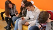 Schüler des Pädagogiums Schwerin gucken auf ihre Smartphones © NDR Foto: NDR