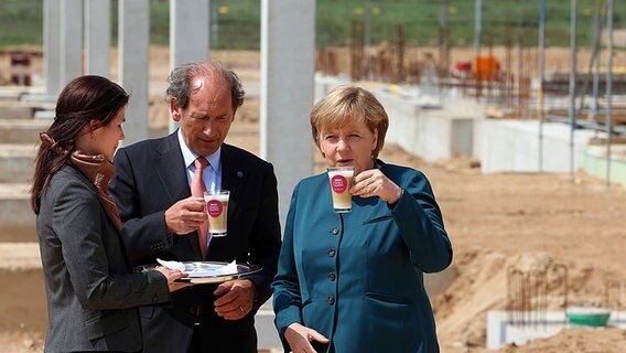 Bundeskanzlerin Angela Merkel (r.) und Nestlé-CEO Paul Bulcke trinken in Schwerin bei der Grundsteinlegung für das Kaffeekapsel-Werk des Nestlé-Konzerns eine Tasse Kaffee. © dpa-Bildfunk Foto: Jens Büttner