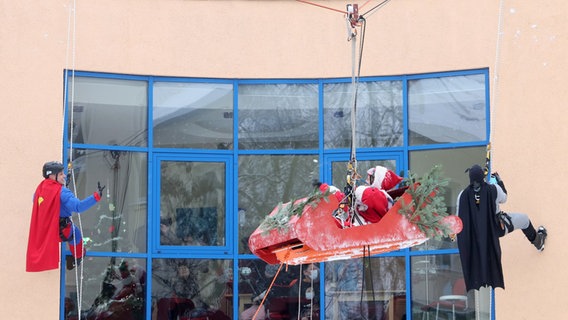 Superhelden begleiten den Nikolaus in seinem fliegenden Schlitten, der Geschenke zu den jungen Patienten der Kinder- und Jugendklinik der Universitätsmedizin bringt. Superhelden begleiten den Nikolaus in seinem fliegenden Schlitten, der Geschenke zu den jungen Patienten der Kinder- und Jugendklinik der Universitätsmedizin bringt. © dpa-Bildfunk Foto: Bernd Wüstneck
