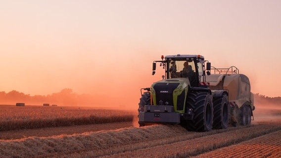Ein Traktor auf einem Feld bei Abendsonne. © Nancy Meinelt 