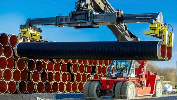 Mit einem Spezialkran werden im Hafen von Sassnitz-Mukran Rohre der Erdgastraße Nord Stream auf einem Lagerplatz transportiert. (Archiv 06.12.2016) © dpa-Zentralbild Foto: Jenns Büttner/dpa