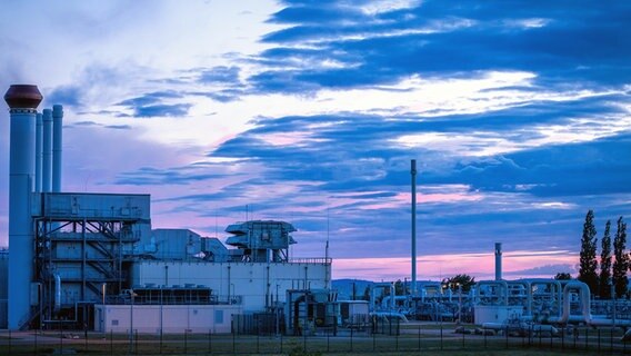 Rohrsysteme und Absperrvorrichtungen in der Gasempfangsstation der Ostseepipeline Nord Stream 1 und der Übernahmestation der Ferngasleitung OPAL (Ostsee-Pipeline-Anbindungsleitung) sind vor Sonnenaufgang zu sehen. © Jens Büttner/dpa 