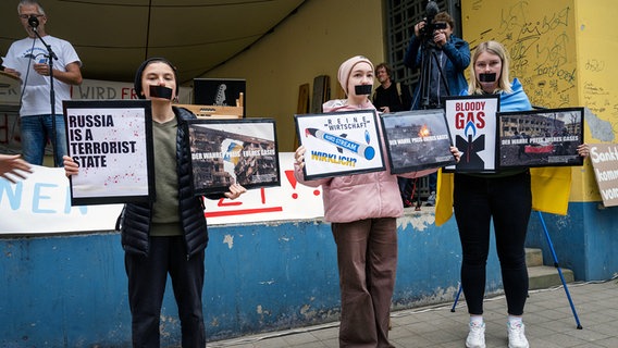 Lubmin: Aktivistinnen aus der Ukraine protestieren mit ihren Plakaten gegen die Öffnung der deutsch-russischen Gaspipeline Nord Stream 2. © Stefan Sauer/dpa +++ dpa-Bildfunk +++ Foto: Stefan Sauer/dpa +++ dpa-Bildfunk +++