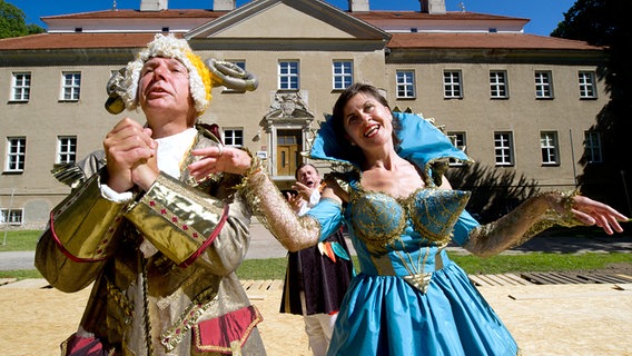 Zwei Schauspieler agieren in opulenten Kostümen vor einem Schloss. © dpa Foto: Stefan Sauer