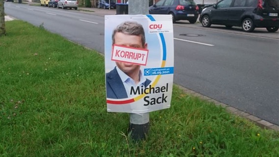 Wahlplakat von Michael Sack (CDU) mit einem Aufkleber mit den Worten "Korrupt"  