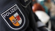Das Wappen der Polizei Mecklenburg-Vorpommern an der Uniform eines Polizeibeamten. © dpa/picture alliance Foto: Jens Büttner
