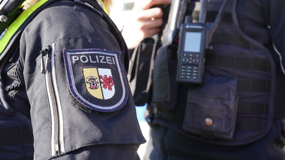 Das Landeswappen der Polizei Mecklenburg-Vorpommern ist an der Uniform einer Polizistin zu sehen. © dpa Foto: Marcus Brandt