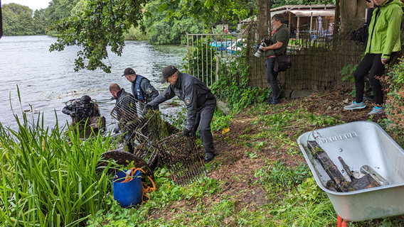 Polizeitaucher holen in Schwerin mit Muscheln bewachsene Möbel aus einem See. © NDR Foto: Christoph Loose