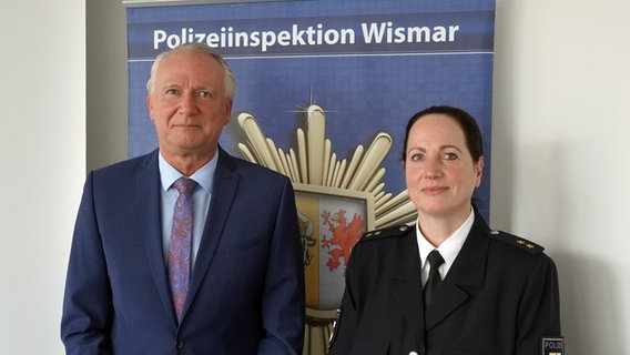 Zwei Personen stehen vor einer Wand mit der Aufschrift "Polizeiinspektion Wismar". © NDR Foto: Christoph Woest