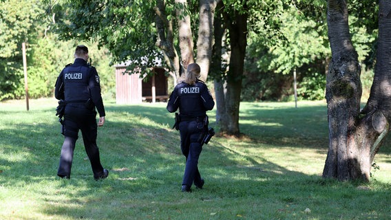 Pragsdorf: Zwei Polizisten sind am See in Pragsdorf unterwegs, wo in unmittelbarer Nähe der Sechsjährige am 14.09.2023 mit schwersten Stichverletzungen gefunden wurde, an denen er später verstarb. © dpa Bildfunk Foto: Bernd Wüstneck