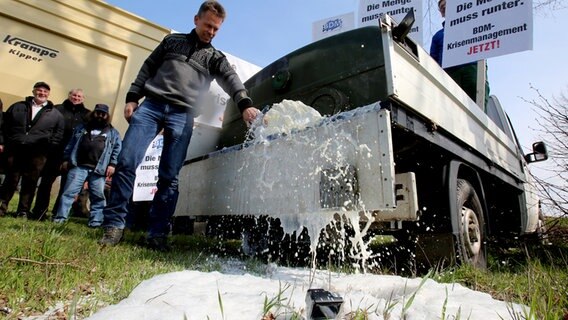 Milchviehhalter vergießen Milch auf einem Acker © DPA-Bildfunk Foto: Bernd Wüstneck