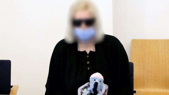 Die angeklagte Mutter im Prozess um den gewaltsamen Tod der sechsjährigen Leonie aus Torgelow sitzt mit einem Stofftier im Saal des Amtsgerichts. © dpa-Bildfunk Foto: Bernd Wüstneck