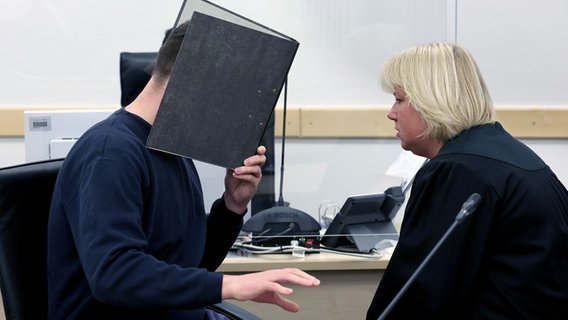 Rostock: Der Angeklagte (l) im Prozess wegen dreifachen Mordes und Beate Falkenberg, Rechtsanwältin, warten im Gerichtssaal auf die Fortsetzung des Prozesses. © dpa-Bildfunk Foto: Bernd Wüstneck