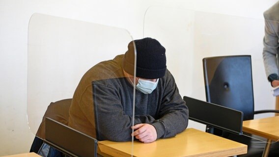 Der Angeklagte sitzt vor Prozessbeginn auf der Anklagebank des Landgerichts Stralsund. © dpa Foto: Frank Hormann