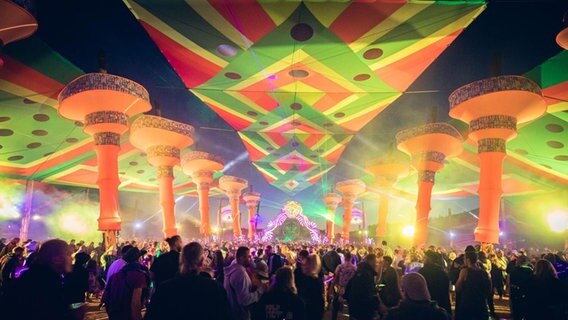 Junge Menschen feiern auf einem psychedelisch geschmückten Festival-Gelände. © Benjamin Genz Fotografie/ Psychedelic Experience Foto: Benjamin Genz Fotografie/ Psychedelic Experience