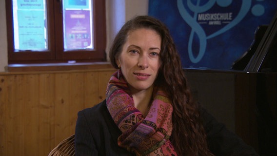 Die Musikerin Olena Radiyevska sitzt in einem Raum der Musikschule in Greifswald. © NDR Foto: screenshot