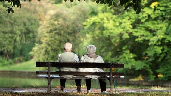 Zwei ältere Menschen sitzen auf einer Bank im Grünen. © dpa-Zentralbild/dpa Foto: Sebastian Kahnert