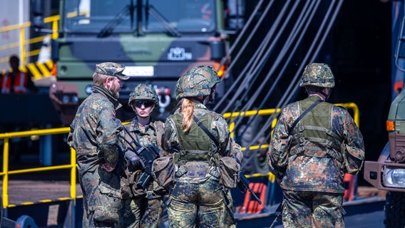 Soldaten und Reservisten sichern bei einer Übung die Verladung von Panzern im Seehafen von Rostock. © dpa Foto: Jens Büttner/dpa