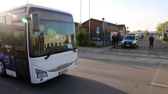 Beamte stehen vor einem Polizeiwagen bei dem gestoppten Bus der Linie 119 in Rostock Elmenhorst. © NDR Foto: Stefan Tretropp
