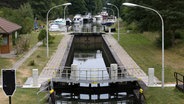 Die Schleusenkammer ist leer, vor den Toren warten die Boote in langen Reihen. © dpa Foto: Bernd Wüstneck