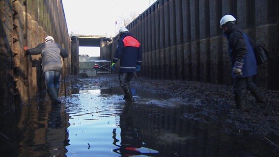 Prüfingenieure in der leergepumpten Schleuse in Parchim. © NDR 