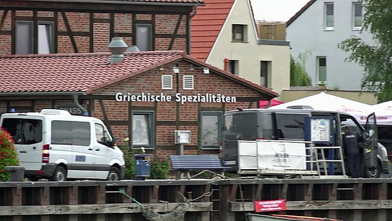Vor einem Restaurant in Wolgast stehen zwei Transporter. An dem Gebäude ist der Schriftzug "Griechische Spezialitäten" zu lesen. © NDR Foto: NDR