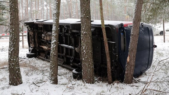 Malchow: Ein dunkler Transporter liegt nach einem Glätteunfall neben der Autobahn A19 © Bernd Wüstneck/dpa Foto: Bernd Wüstneck/dpa