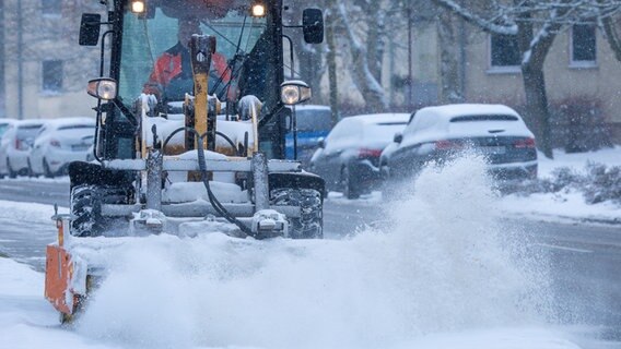 Mecklenburg-Vorpommern, Wismar: Mit einer speziellen Kehrmaschine wird ein Fußweg bei starkem Schneefall geräumt. © dpa Foto: Jens Büttner