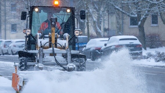 Ein Schneepflug fährt auf einer verschneiten Straße in Mecklenburg-Vorpommern. © NDR Foto: Jens Büttner/dpa