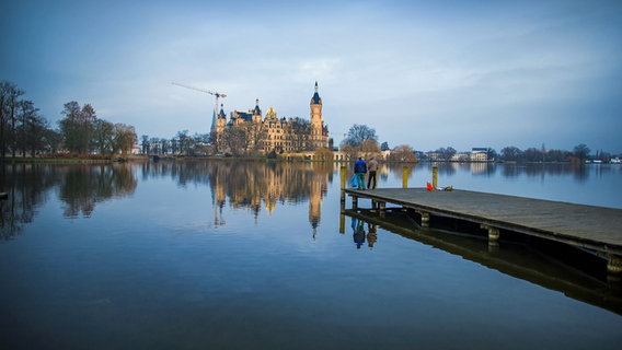 Angler stehen am auf einem Bootssteg vor dem Schweriner Schloss in Schwerin. © dpa - Bildfunk Foto: Jens Büttner
