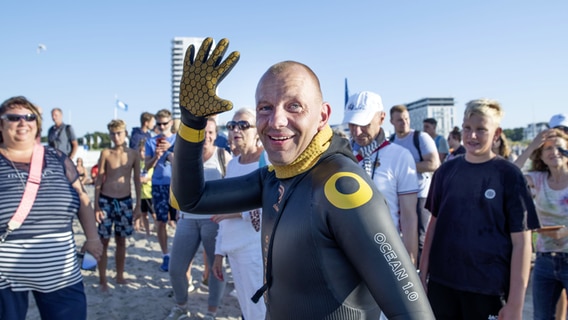 Extremsportler Patrick Schuster-Agelander kommt Freitag Abend am Strand von Warnemünde an. Der Doberaner ist als Erster die 42 Kilometer von Gedser (Dänemark) nach Warnemünde geschwommen. © dpa Foto: Frank Hormann