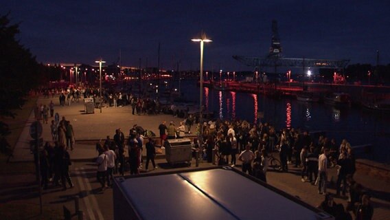 Blick auf feiernde Menschen im Rostocker Stadthafen. 