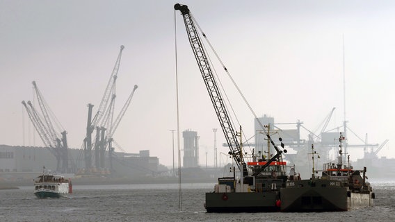 Rostock: Im Seekanal sind Arbeitsschiffe beim Ausbaggern, nachdem der offizielle Startschuss für die Arbeiten gegeben wurde. © Bernd Wüstneck/dpa +++ dpa-Bildfunk +++ Foto: Bernd Wüstneck/dpa +++ dpa-Bildfunk +++