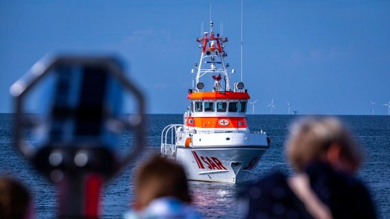 Der 28 Meter lange und fast 4.000 PS starke Seenotrettungskreuzer "Nis Randers" wird bei einer Einsatzübung auf der Ostsee vor der Halbinsel Fischland-Darf-Zingst von Touristen auf der Seebrücke beobachtet. © picture alliance/dpa Foto: Jens Büttner