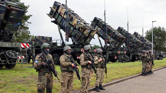 Deutsche und ukrainische Soldaten stehen beim Besuch des ukrainischen Präsidenten Selenskyj auf einem Truppenübungsplatz vor Flugabwehrraketensystemen vom Typ Patriot. © dpa-Bildfunk Foto: Jens Büttner