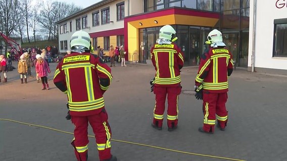 Feuerwehrleute steht vor einer Schule  Foto: Stefan Tretrop