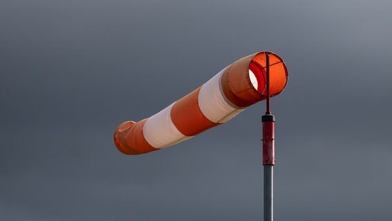 Ein rot-weisser Windsack vor grauem Himmel © picture alliance/dpa | Silas Stein Foto: picture alliance/dpa | Silas Stein