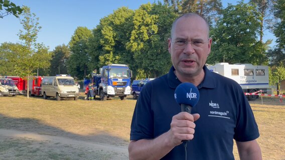 NDR Reporter vor Feuerwehr- und THW-Fahrzeugen © NDR 
