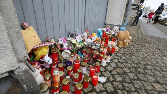 Vor dem Eingang eines Hauses in Torgelow, wo am 12.01.2019 eine Sechsjährige ums Leben kam, stehen Gedenkkerzen. © dpa-Zentralbild Foto: Bernd Wüstneck