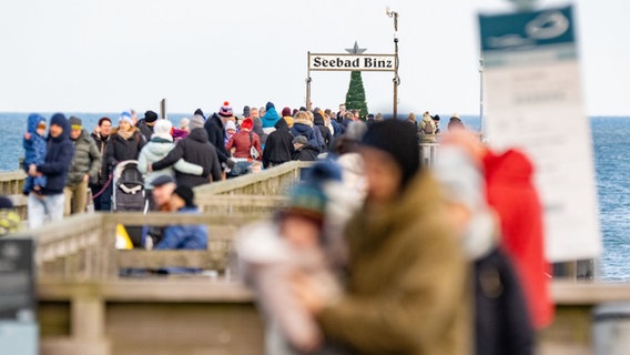 Urlauber und Touristen sind an der Ostsee auf der Seebrücke in Binz unterwegs. © dpa-Bildfunk Foto: Stefan Sauer