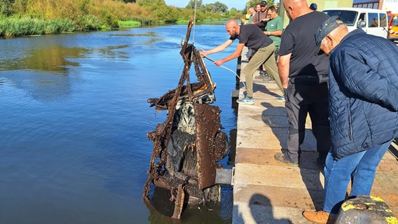 Das demolierte und verrostete Wrack eines Trabanten wird aus dem Wasser geholt. © Robert Baumann Foto: Robert Baumann