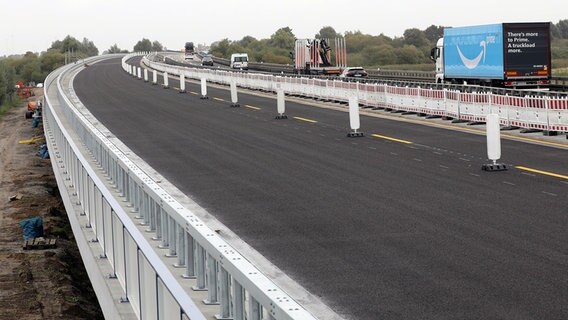 Die Trasse in Richtung Westen der neugebauten Ostseeautobahn bei Tribsees (l) kurz vor der Verkehrsfreigabe, rechts rollt der Verkehr über die Behelfsbrücke. © dpa-Bildfunk Foto: Bernd Wüstneck