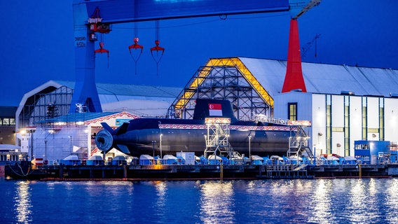 Ein geschmücktes U-Boot liegt vor einer Werft. © tkMS Foto: Axel Heimken