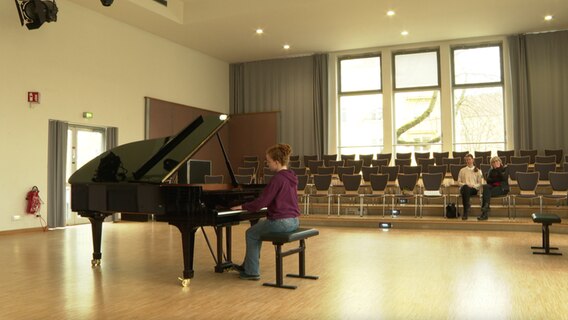 Ein Flügel steht in der großen Halle einer Schule © NDR 