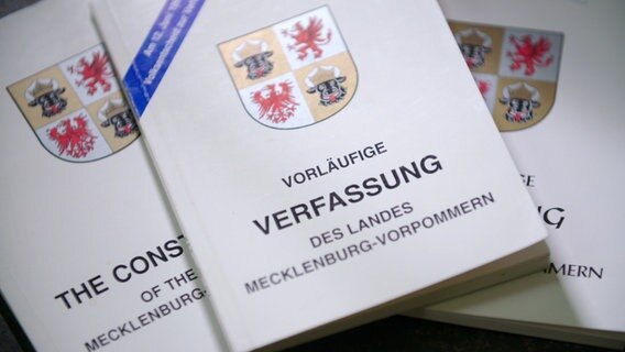 Drei Ausgaben der vorläufigen Landesverfassung Mecklenburg-Vorpommerns liegen nebeneinander. © NDR Foto: Screenshot