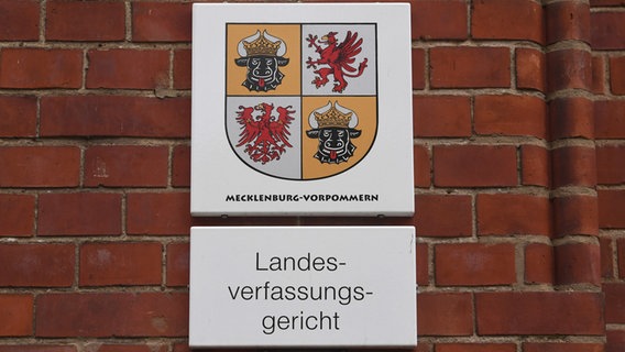 Ein Schild mit der Aufschrift Landesverfassungsgericht Mecklenburg-Vorpommern hängt an einer Backsteinwand.s © ppicture alliance/dpa Foto: Stefan Sauer/dpa